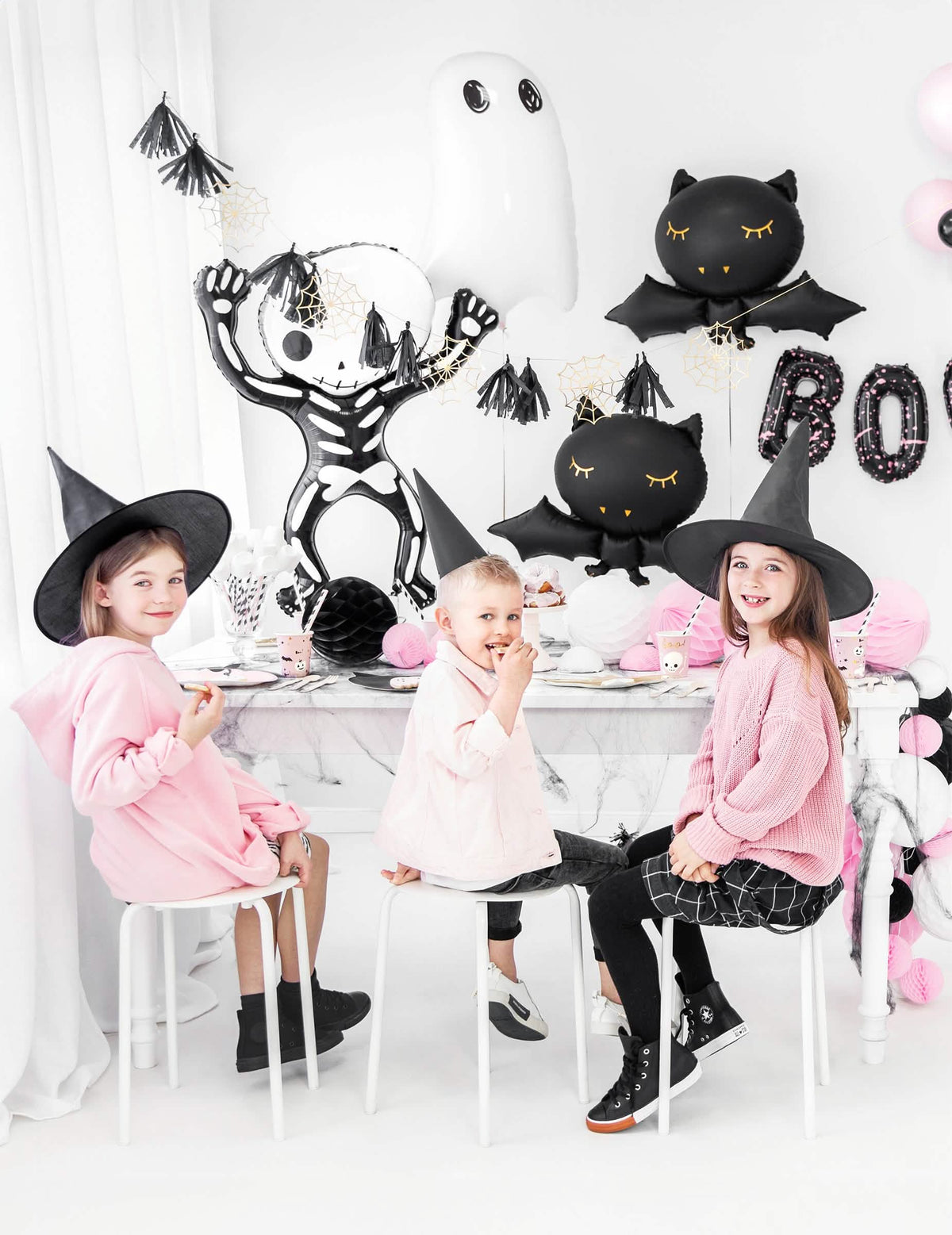 Gustare de halloween cu copii la masă, cu balon din aluminiu în formă de liliac