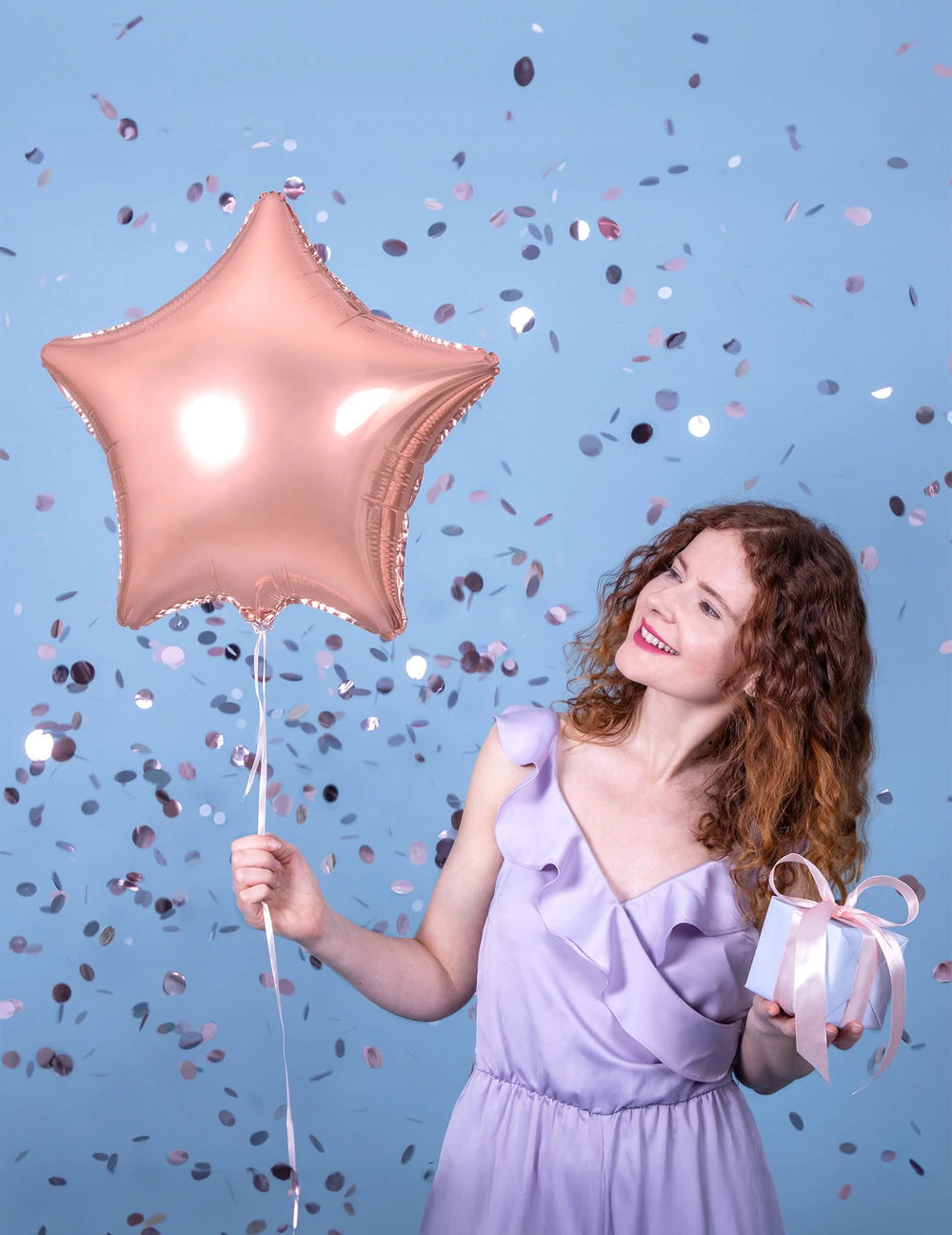 Mise en situation avec une femme du ballon aluminium étoile pour décoration de fête rose gold métallisé