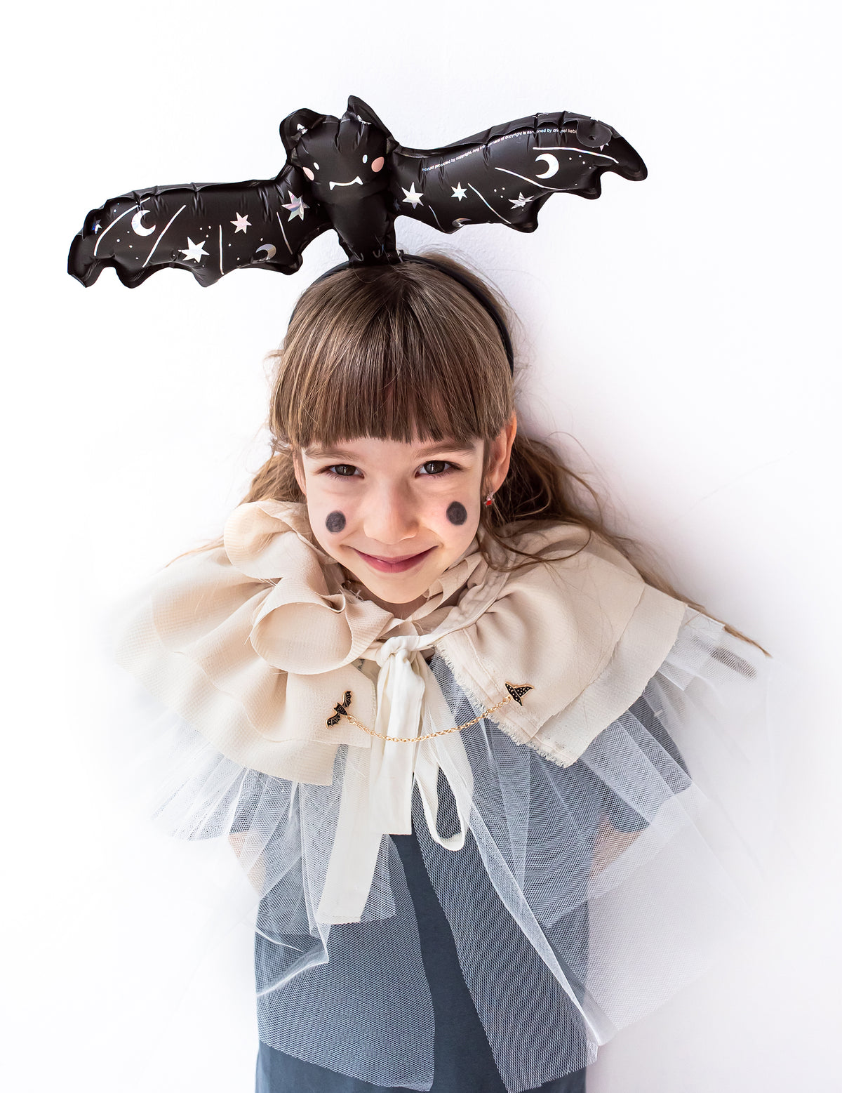 Mise en situation sur la tête d'une enfant du ballon aluminium petite chauve-souris pour fête