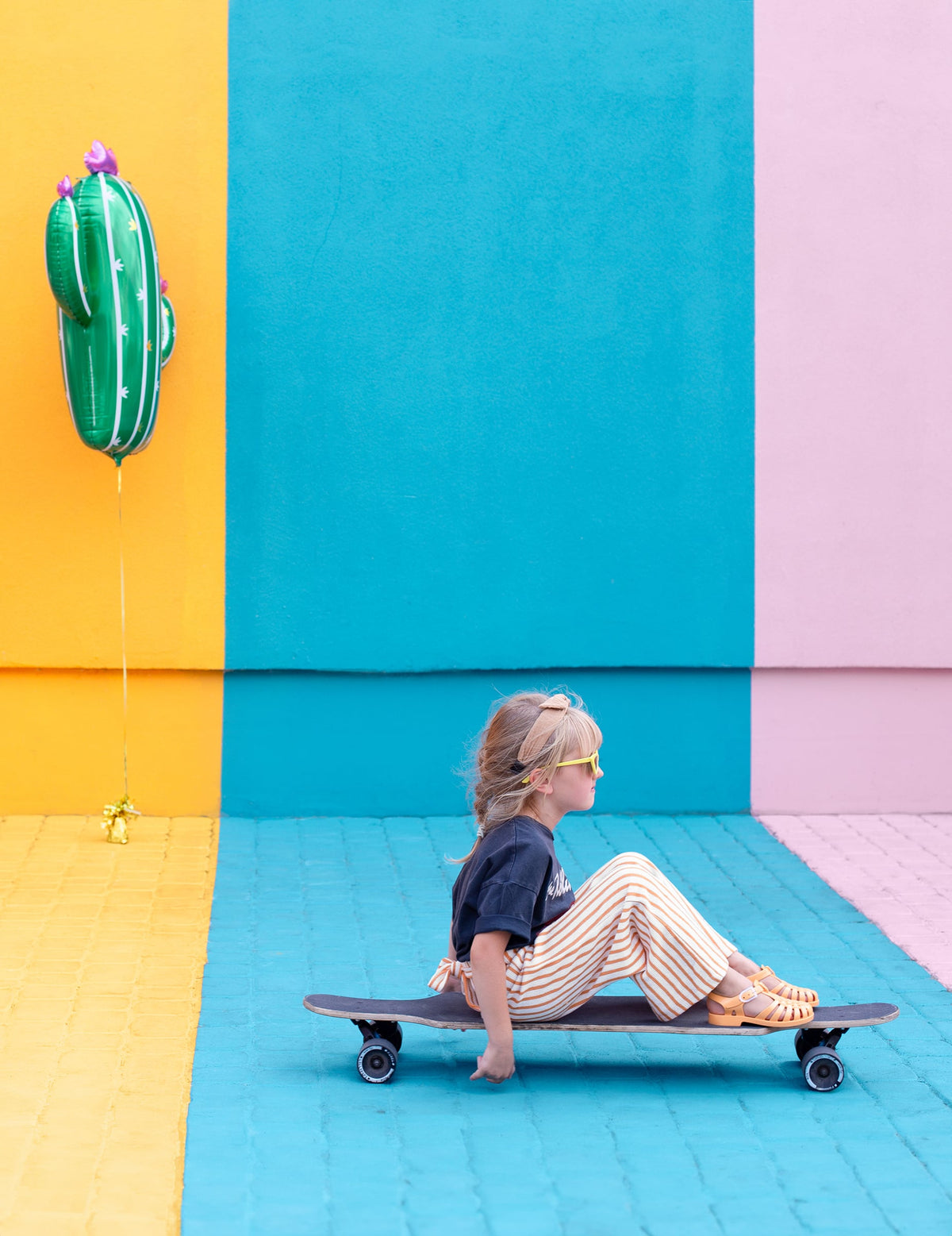 Mise en scène avec enfant sur un skateboard du ballon cactus en fleurs