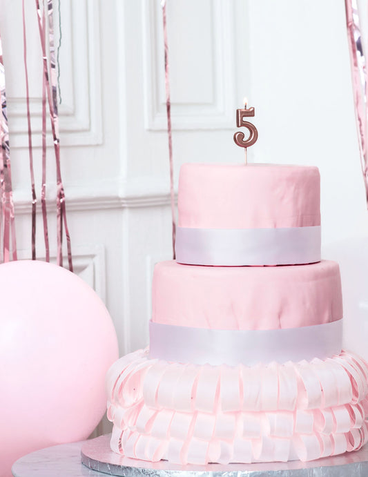 Mise en situation sur un gâteau de la bougie d'anniversaire chiffre 5 rose gold métallisé