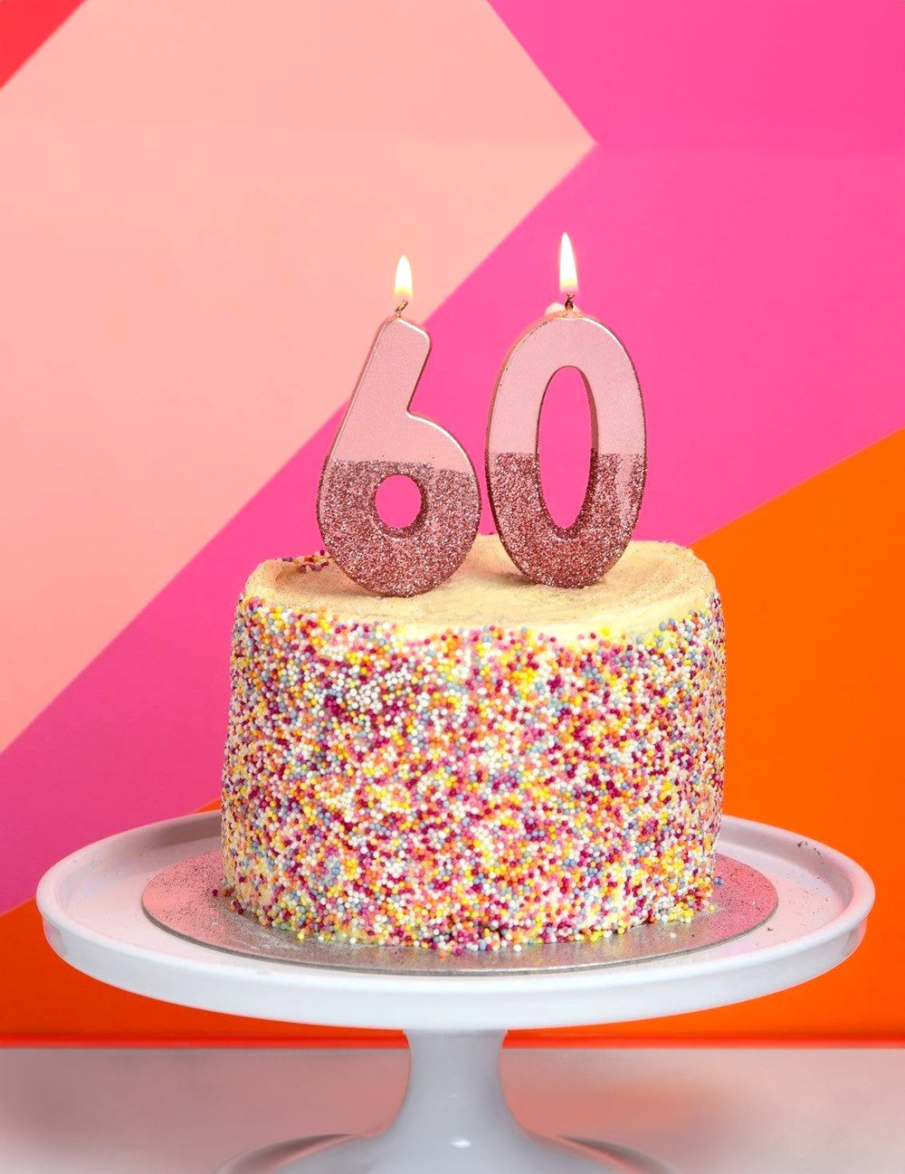 Mise en situation sur un gâteau des chiffres 60 de la bougie sur pique chiffre pour anniversaire rose pailleté