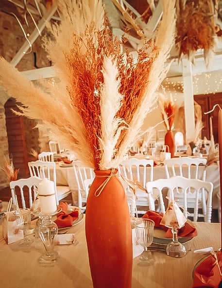 Mise en situation en centre de table du bouquet de broom séché terracotta pour décoration de fête orange