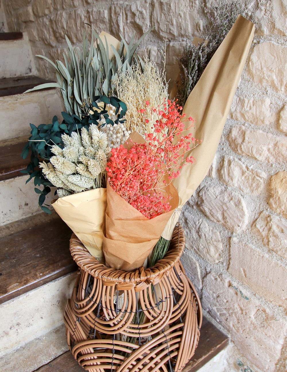 Mise en scène dans un panier en osier du bouquet de gypsophiles séchées pour décoration rose