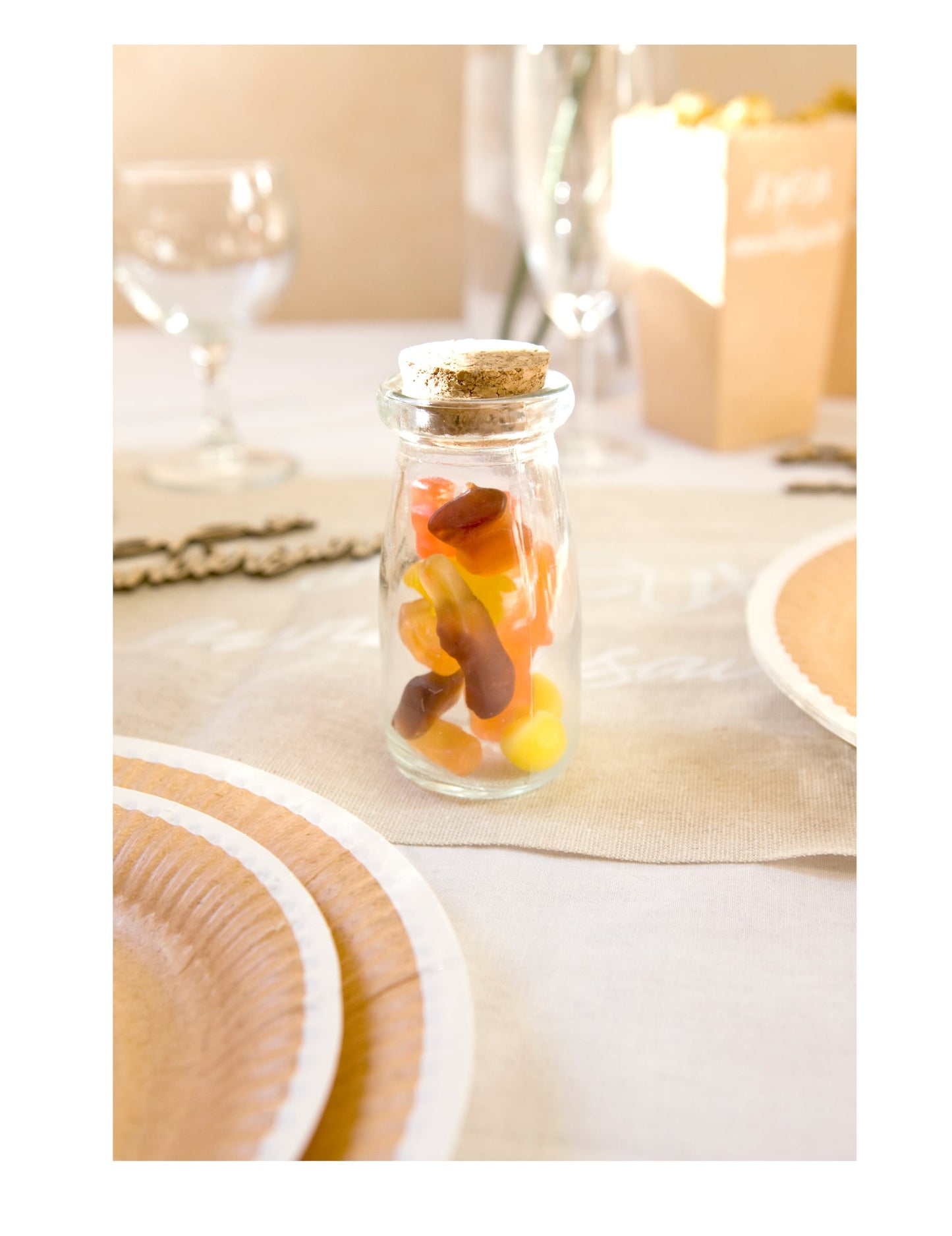 Mise en situation sur une table de fête de la bouteille en verre avec bouchon en liège pour candy bar transparente