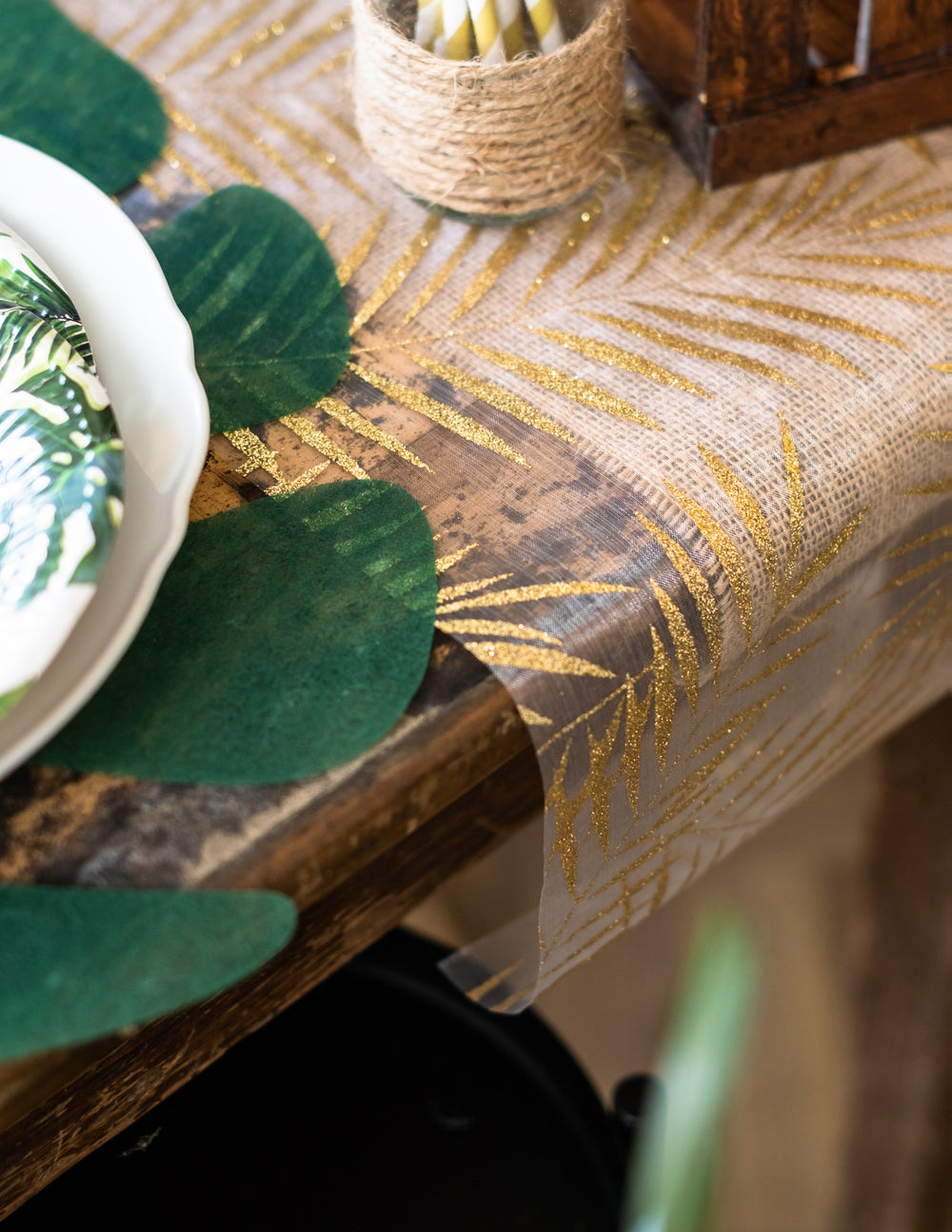 Détail des motifs pailletés du chemin de table en organza palmier pour décoration tropicale chic