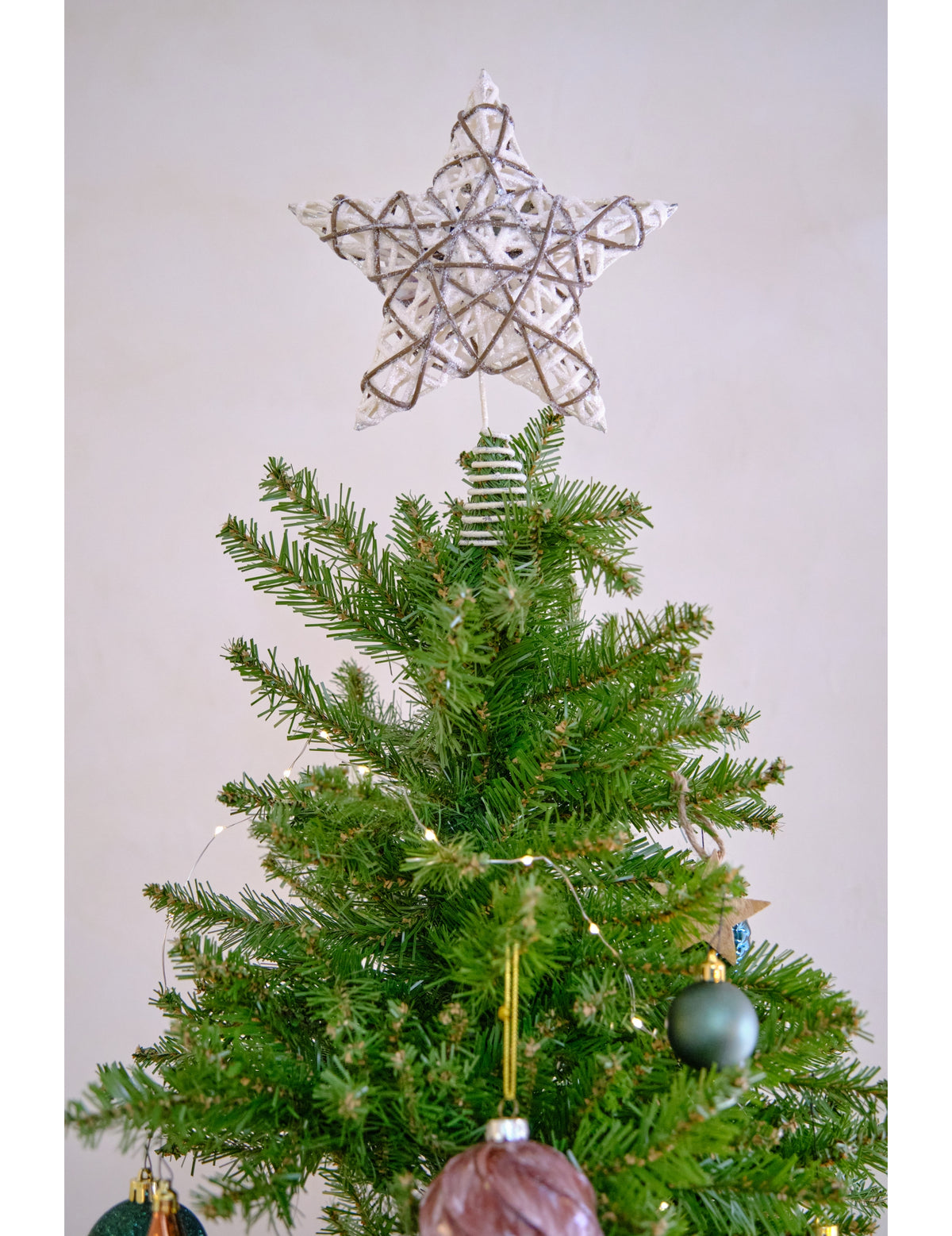 Mise en situation au sommet du sapin du cimier de sapin étoile en rotin