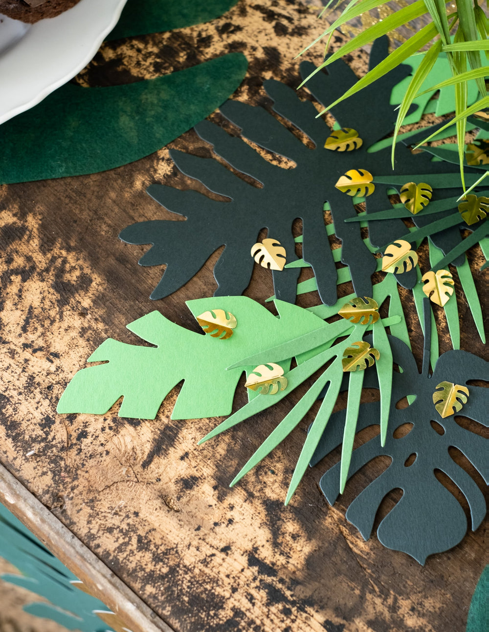 Mise en situation sur une table des confettis de table feuilles tropicales