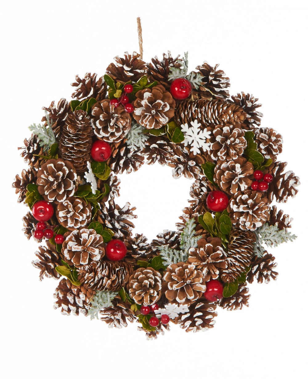 Couronne de noël baies des bois traditionnelle avec pommes de pin enneigées et baies rouges