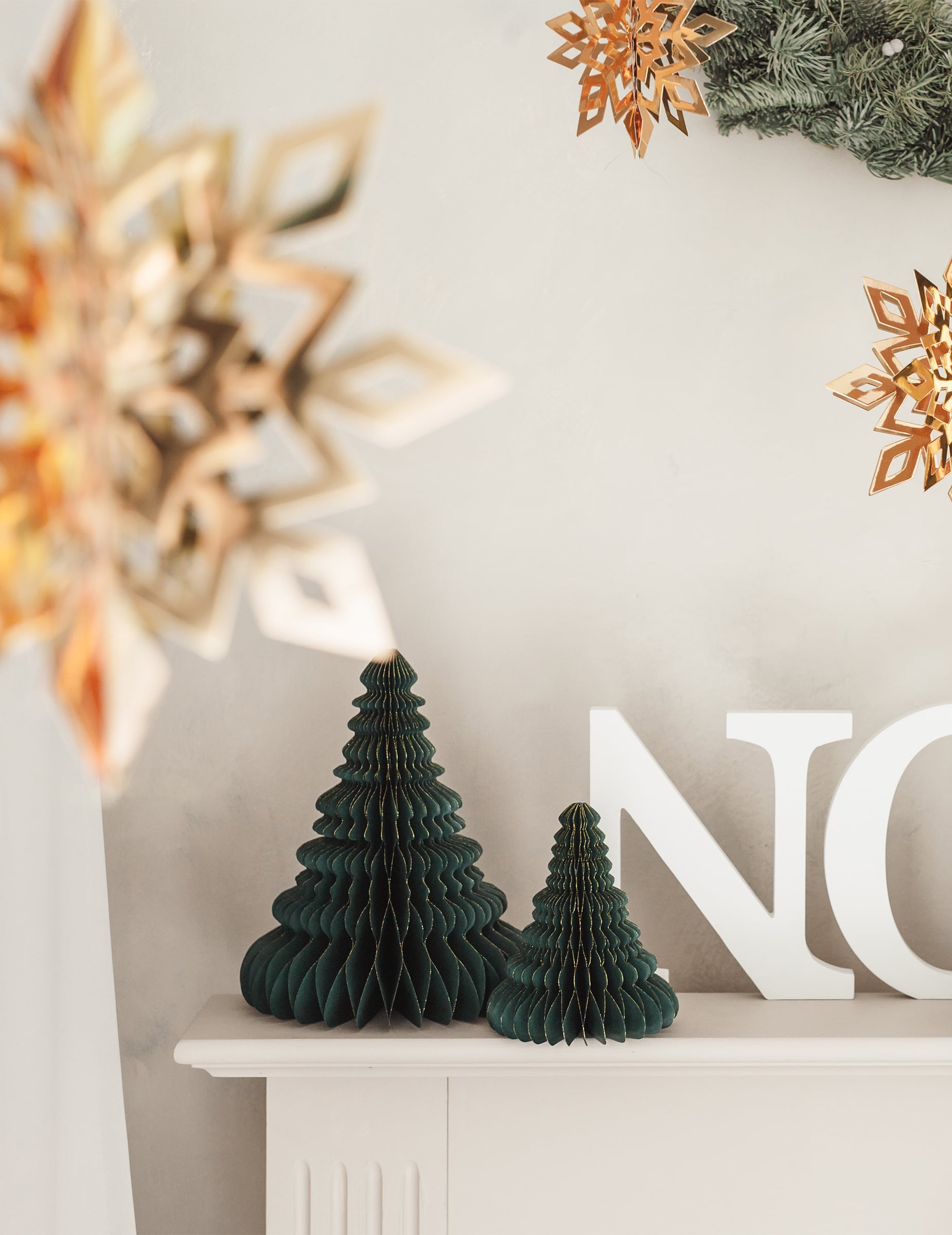Mise en scène avec lettres et flocons de la décoration en papier alvéolé sapin de Noël