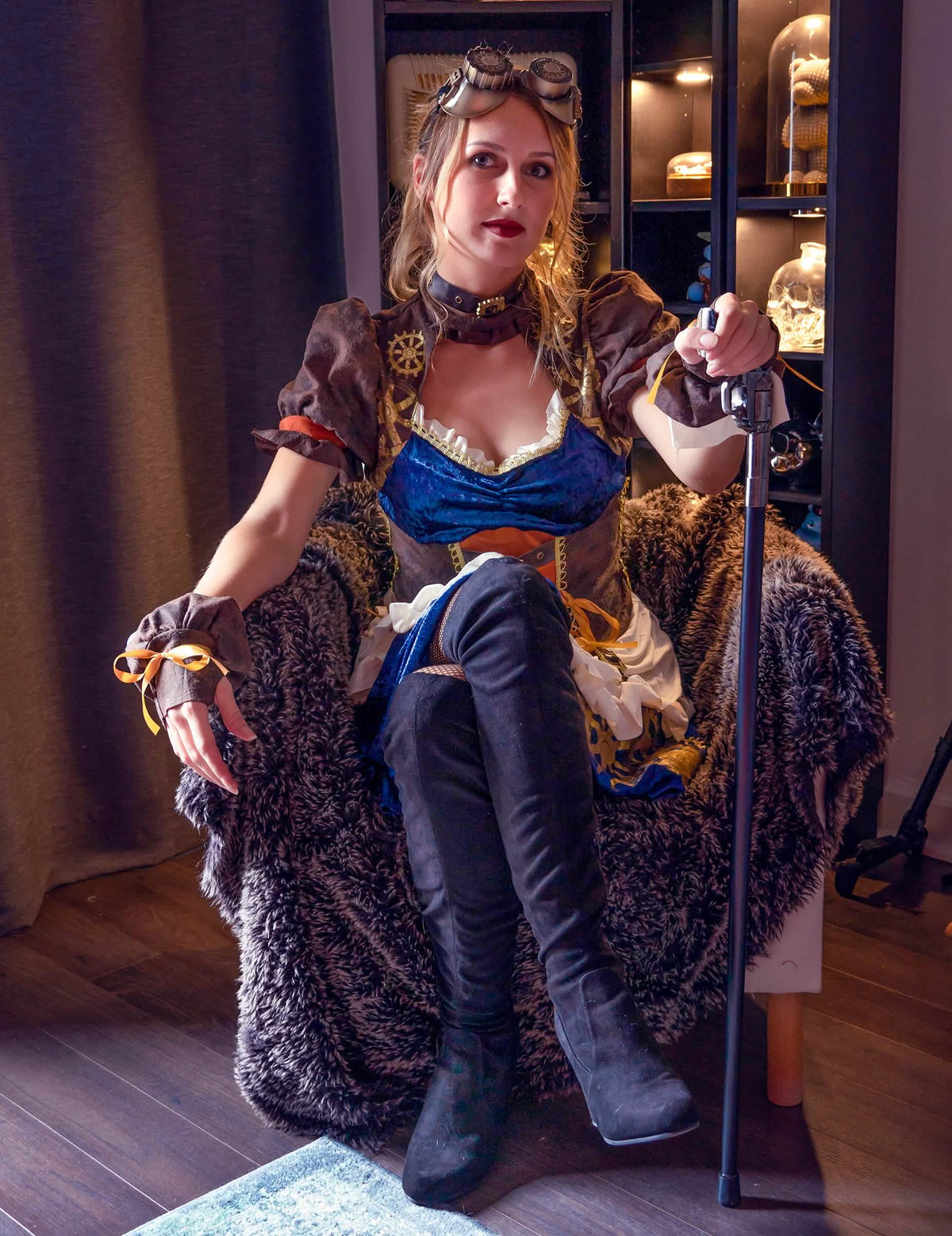 Vedere din față a modelului așezat cu accesorii ale costumului retro-futurist steampunk