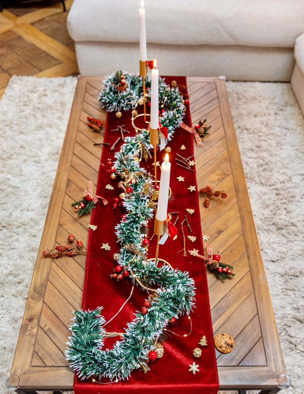 Mise en scène avec bougies de la guirlande de sapin enneigée avec baies