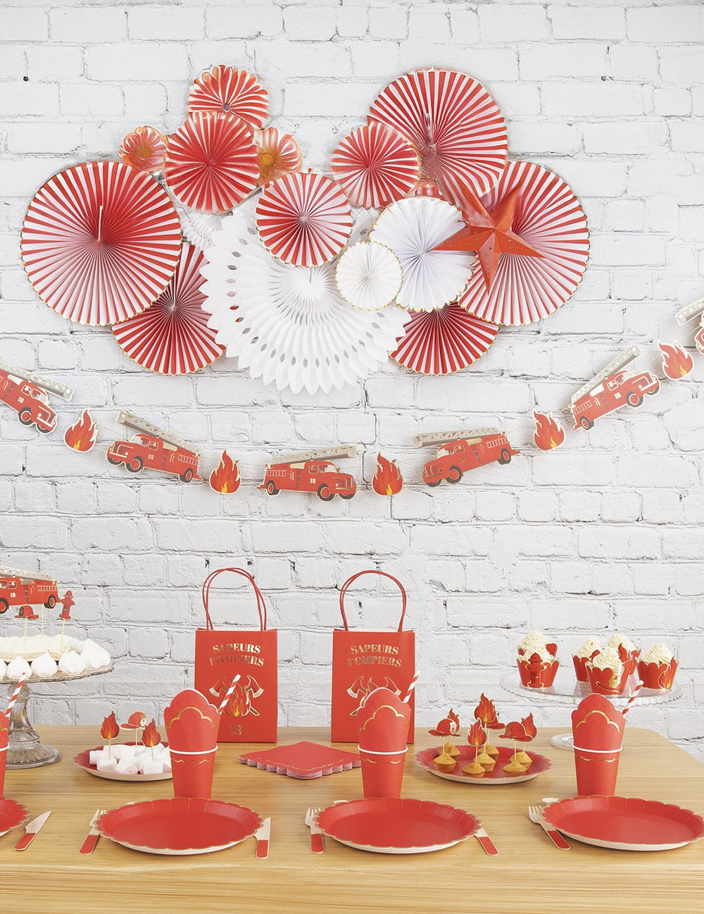 Vue du buffet de fête décoré avec la guirlande en carton Pompier