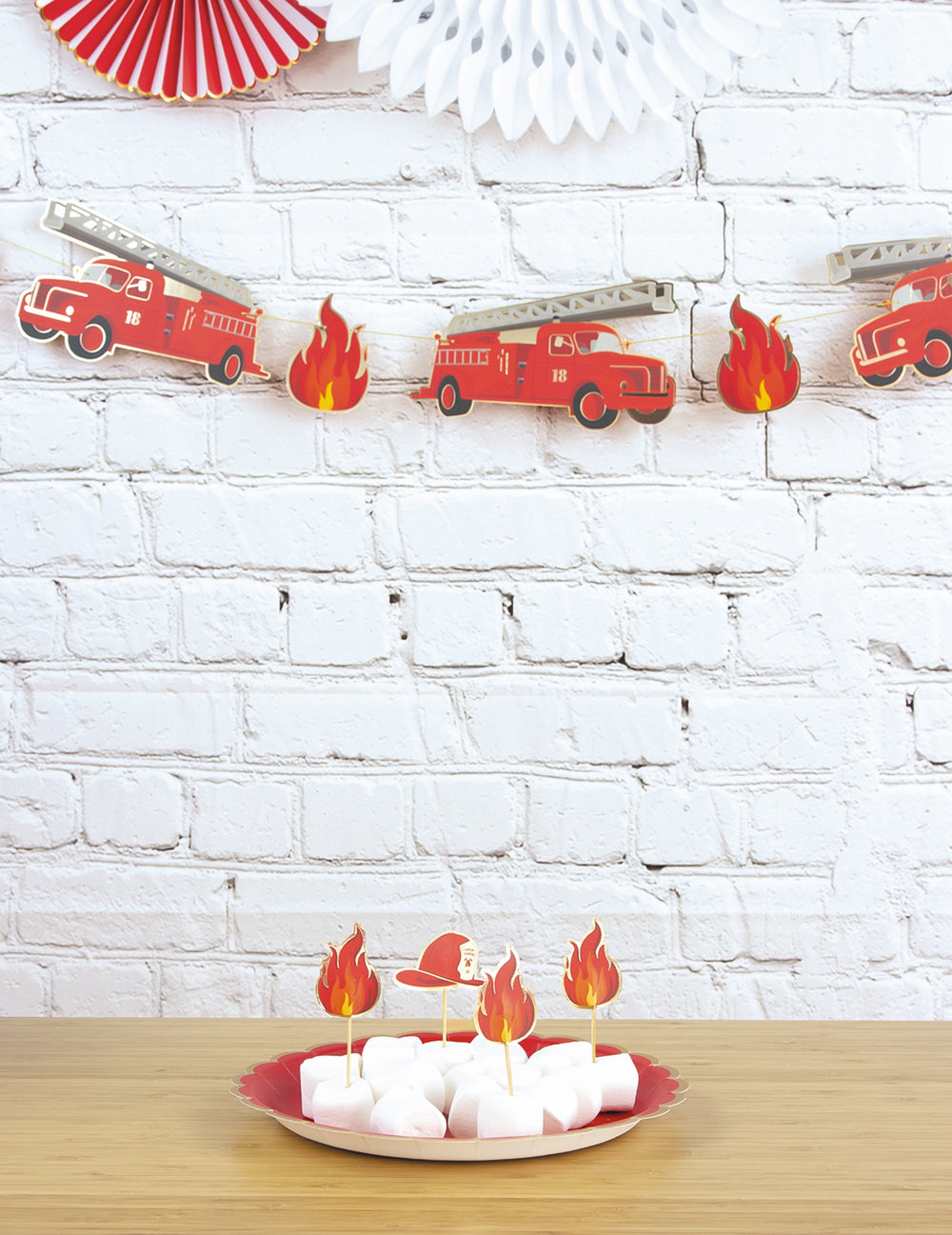 Mise en situation sur une table d'anniversaire de la guirlande en carton Pompier
