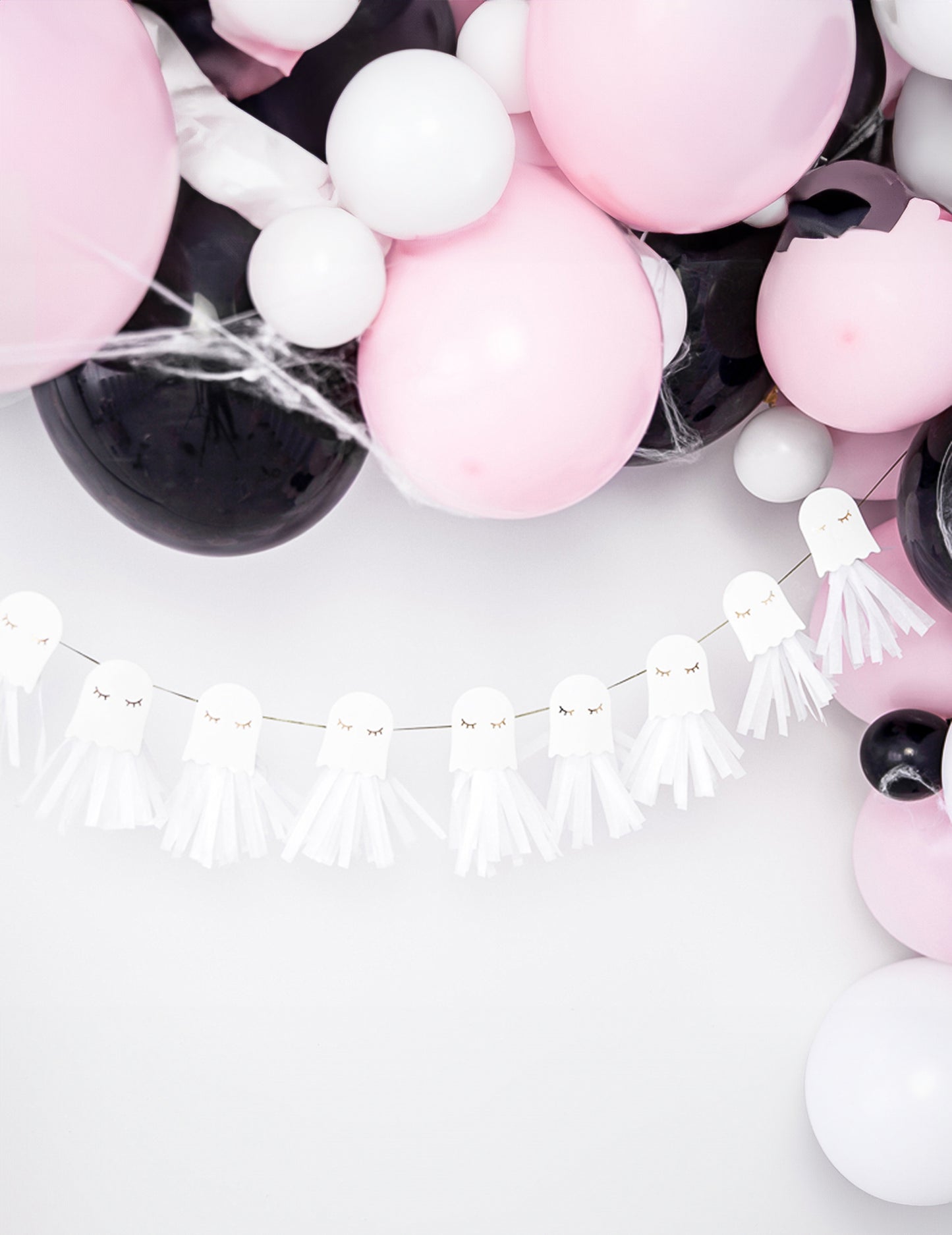 Mise en scène avec ballons de la guirlande en papier fantômes blanche et dorée à monter