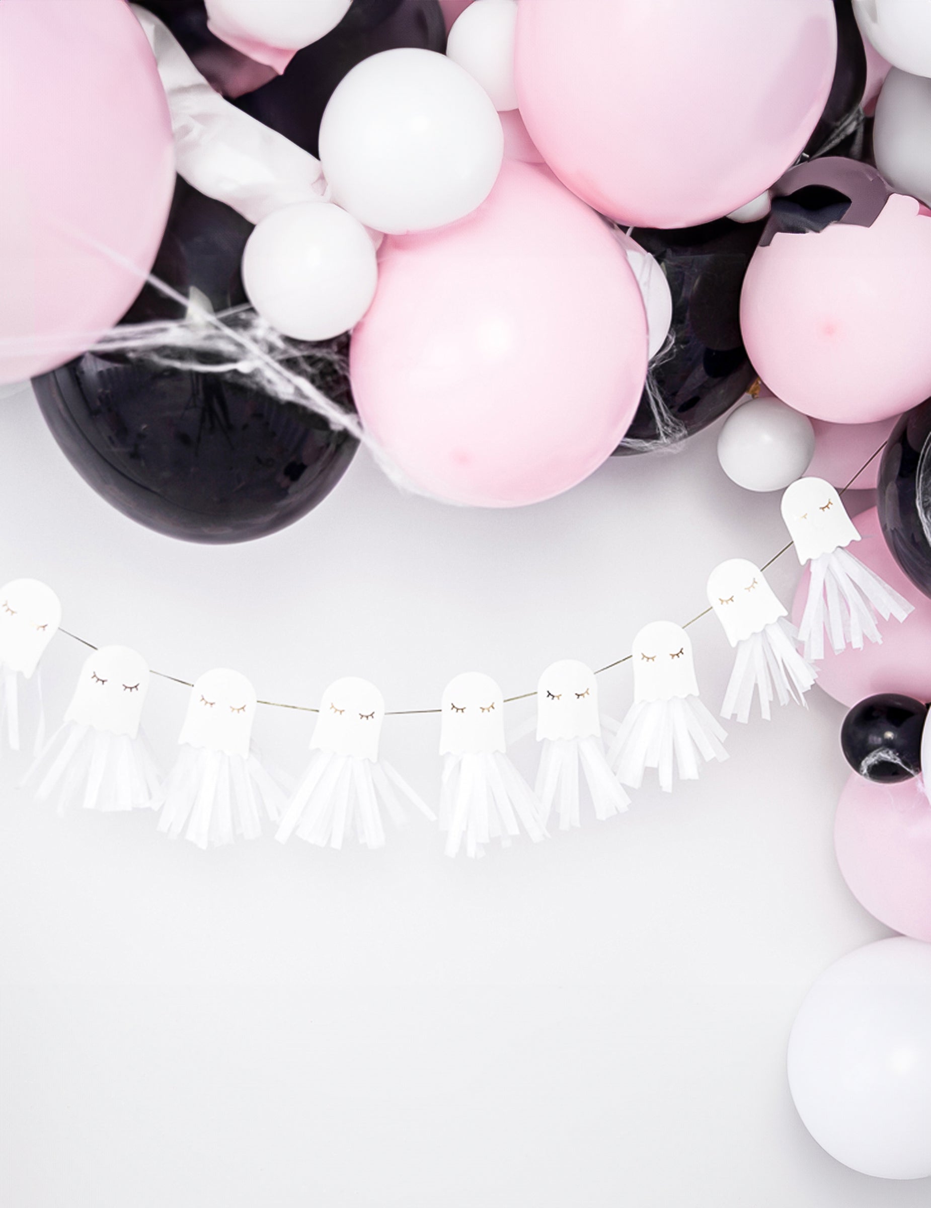 Mise en scène avec ballons de la guirlande en papier fantômes blanche et dorée à monter