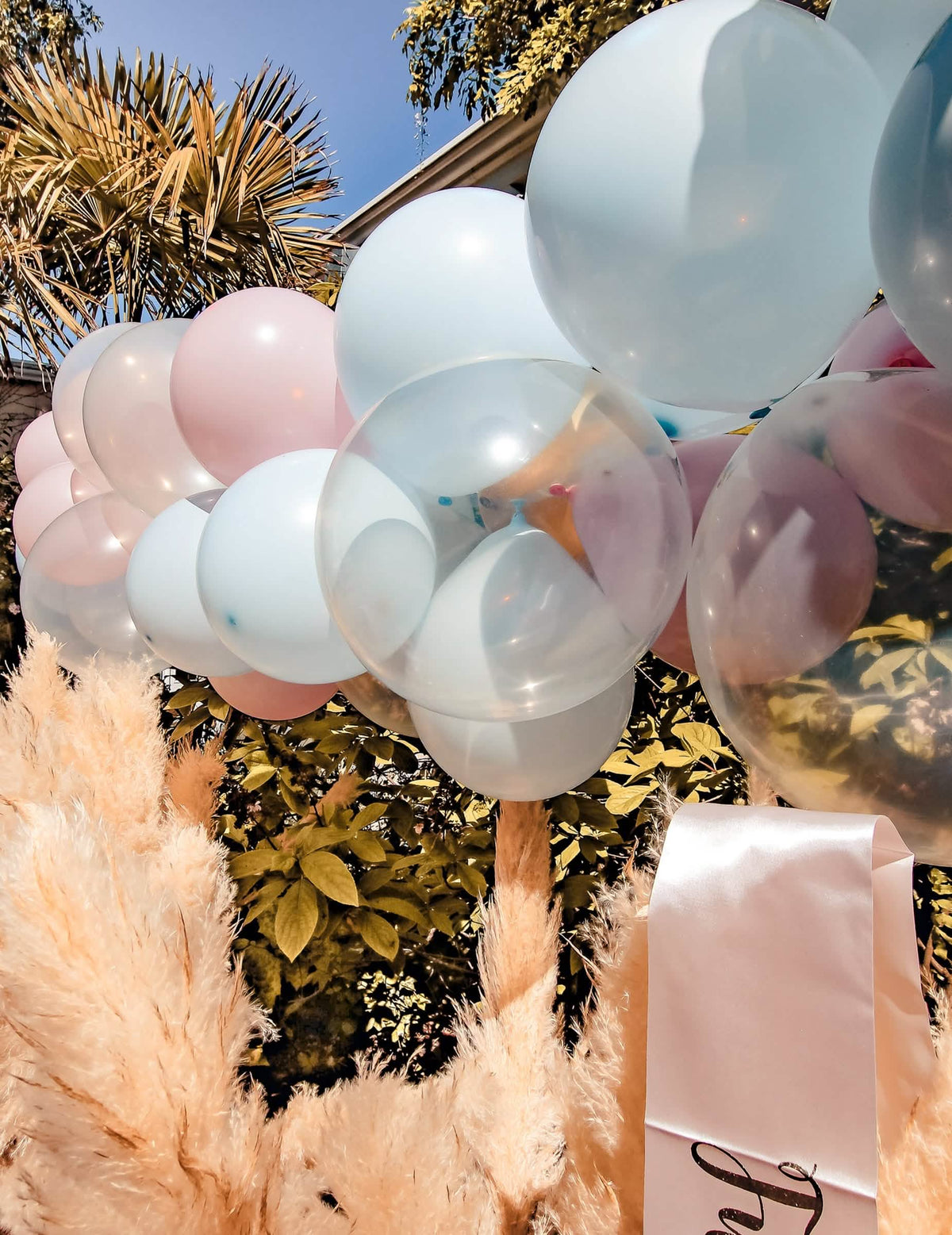 Prim-plan al kitului de arc din 58 de baloane pentru gender reveal albastru și roz alb și auriu