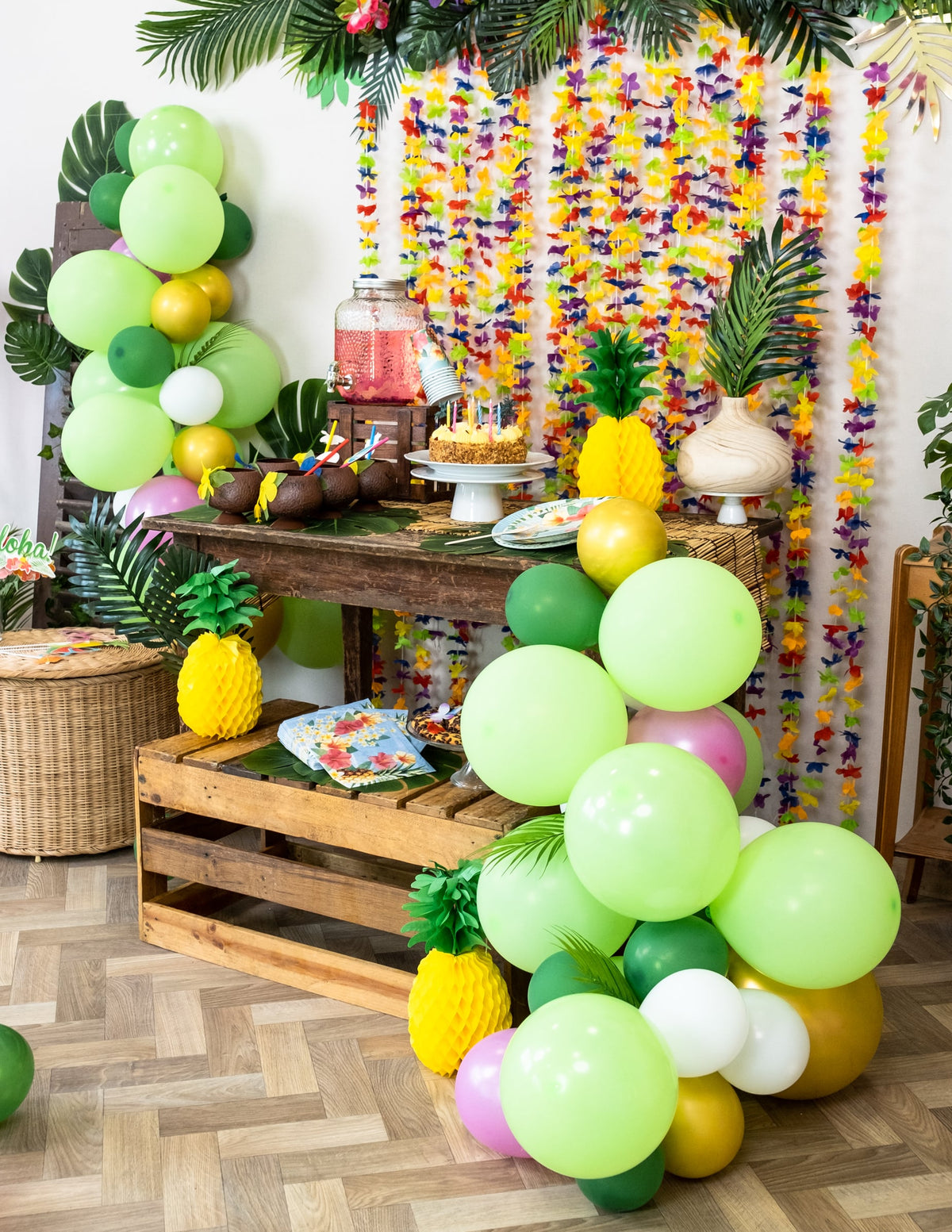 Ambiance festive du buffet avec le kit arche de 70 ballons tropicale et feuilles jungle