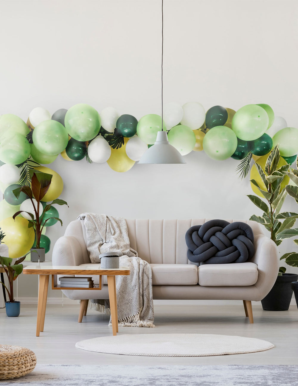 Mise en scène dans un salon du kit arche de 70 ballons tropicale et feuilles jungle