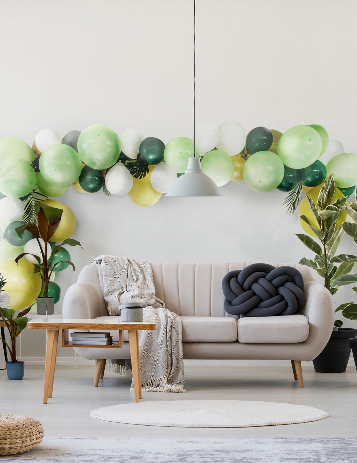 Mise en scène dans un salon du kit arche de 70 ballons tropicale et feuilles jungle