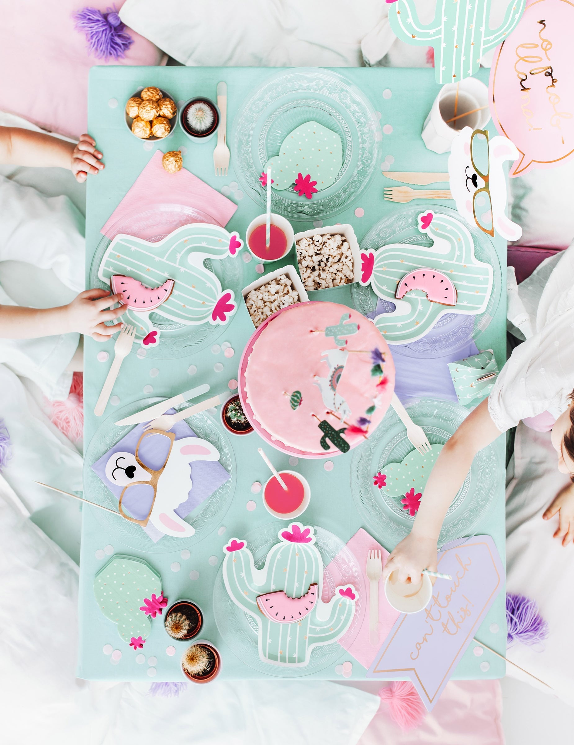 Mise en situation sur une table de fête du kit photobooth lama pastel 5 pièces pour anniversaire