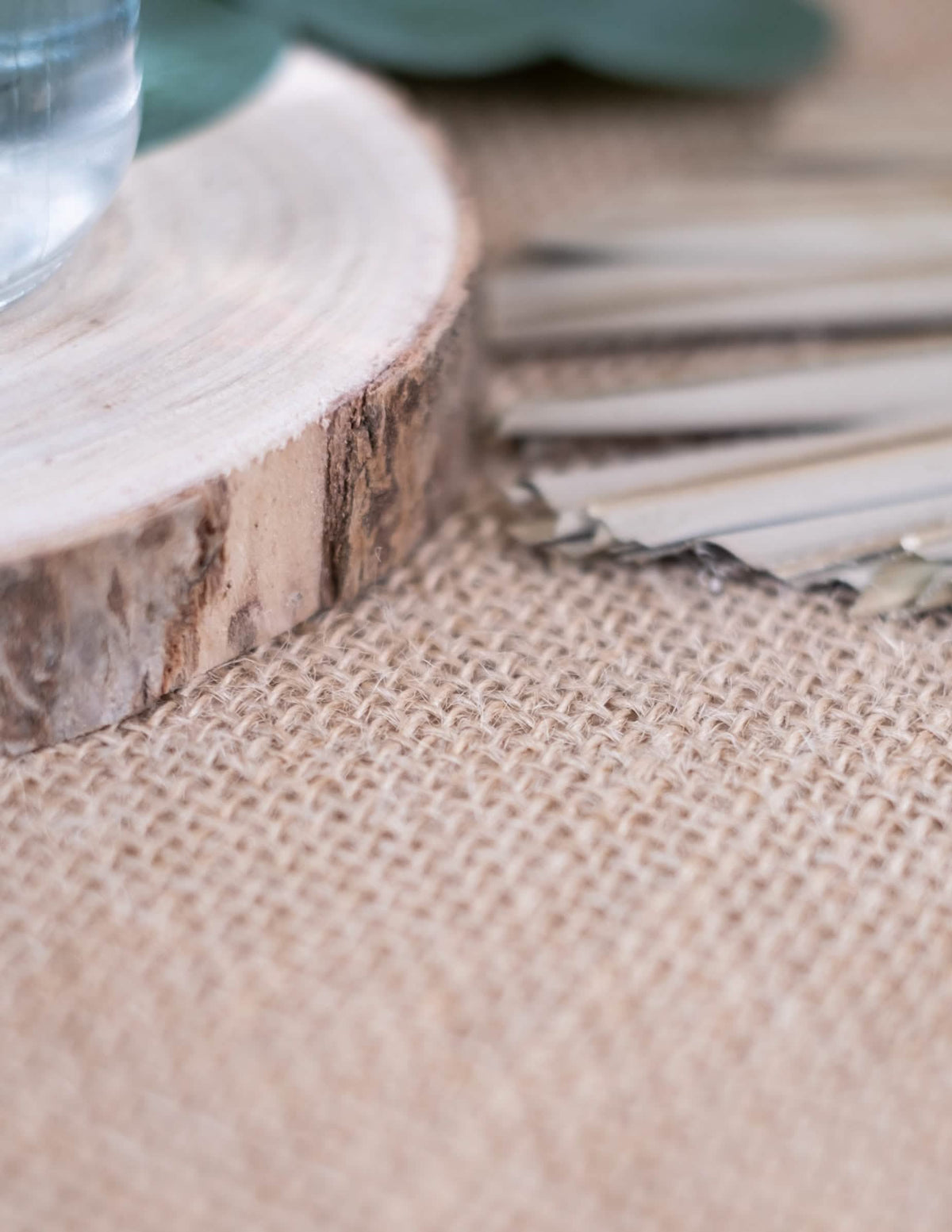 Detaliu de decor cu buștean de lemn al feței de masă dreptunghiulare din iută, boho și naturală