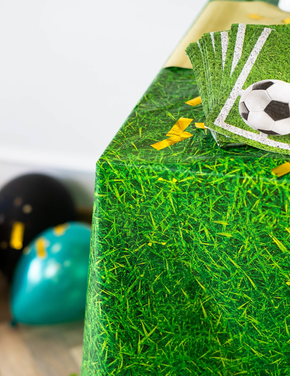Detaliu al colțului și al șervețelelor fotbal ale feței de masă din plastic cu efect de iarbă verde