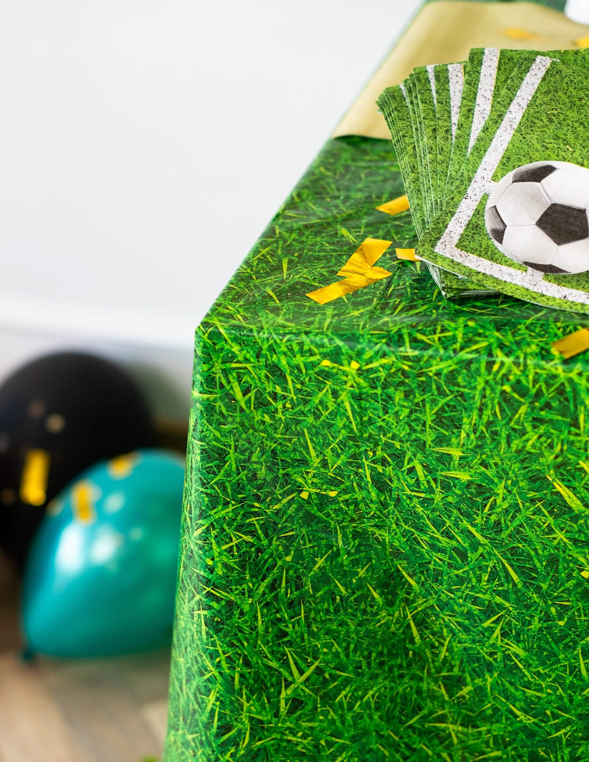 Detaliu al colțului și al șervețelelor fotbal ale feței de masă din plastic cu efect de iarbă verde