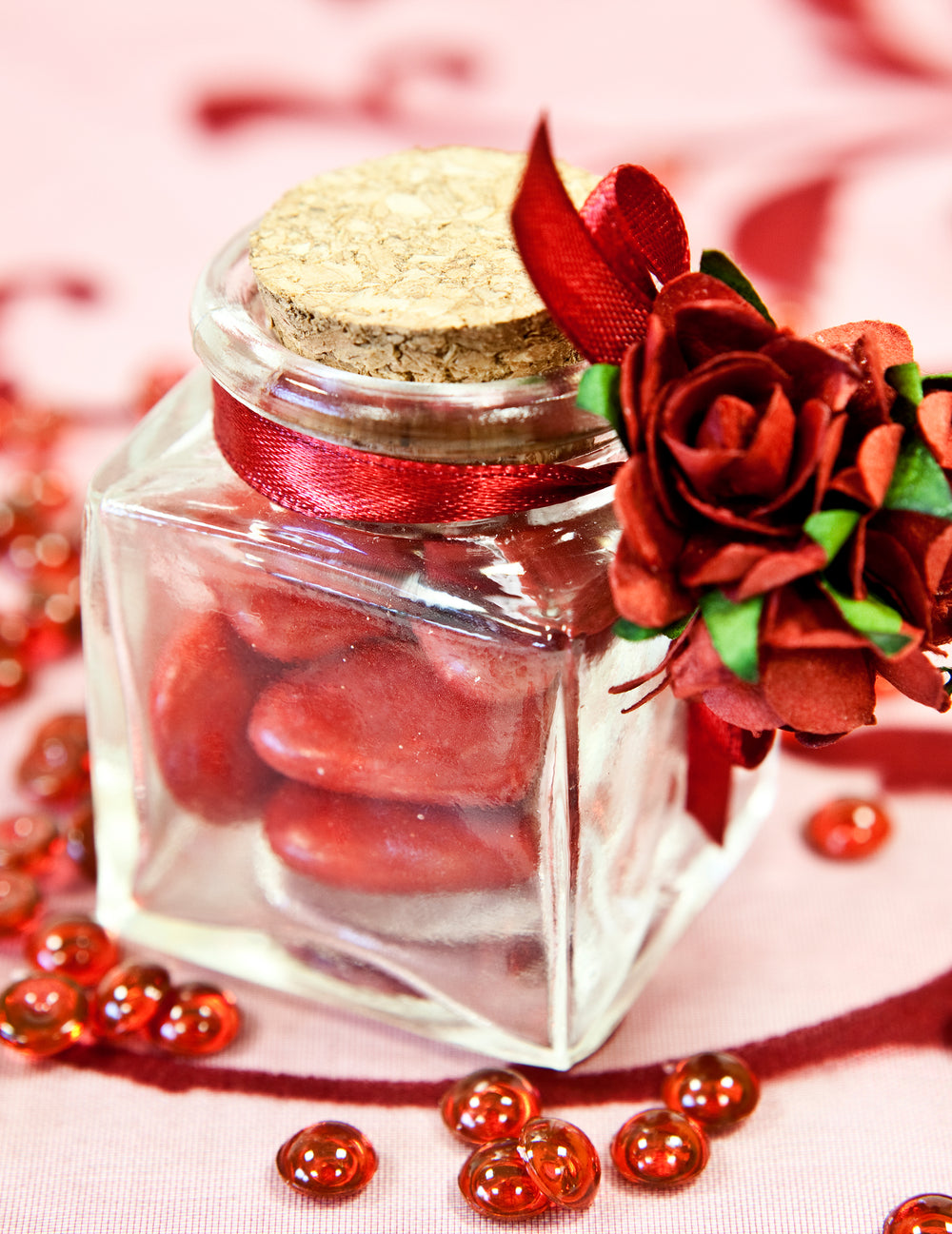 Décoration avec ruban et rose rouge du petit pot en verre carré pour fête