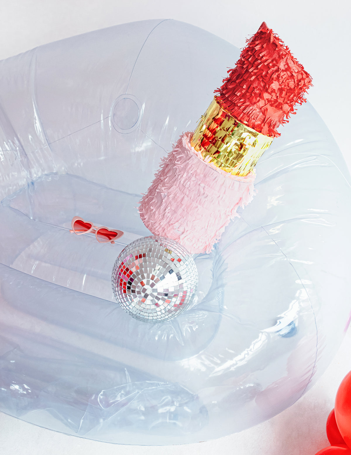 Mise en scène avec boule à facettes et lunettes de la piñata rouge à lèvres