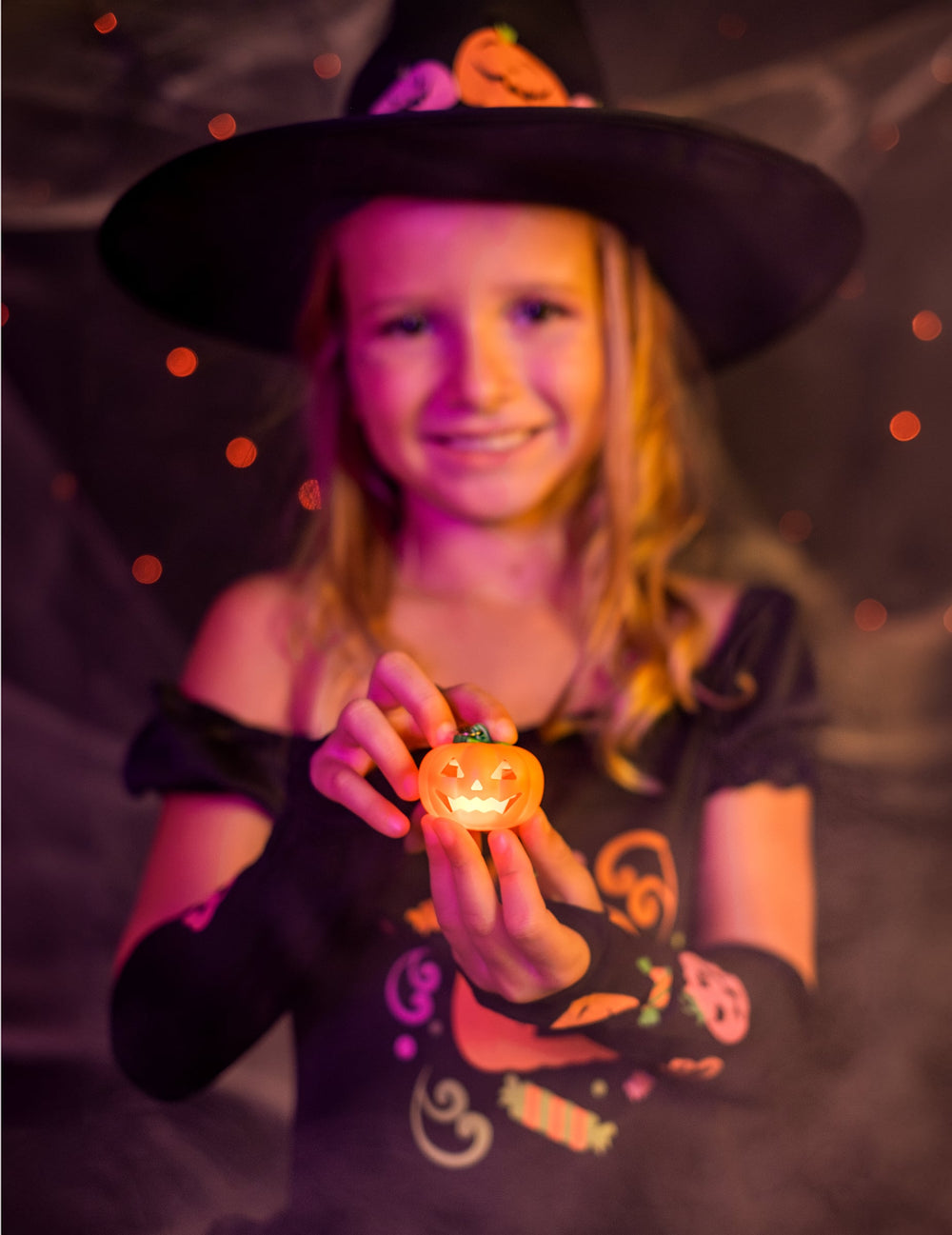 Détail du porte-clé citrouille lumineux tenu par une enfant
