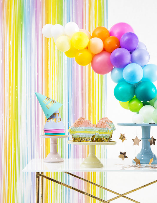 Mise en situation festive du rideau scintillant multicolore pastel pour fête à franges arc-en-ciel