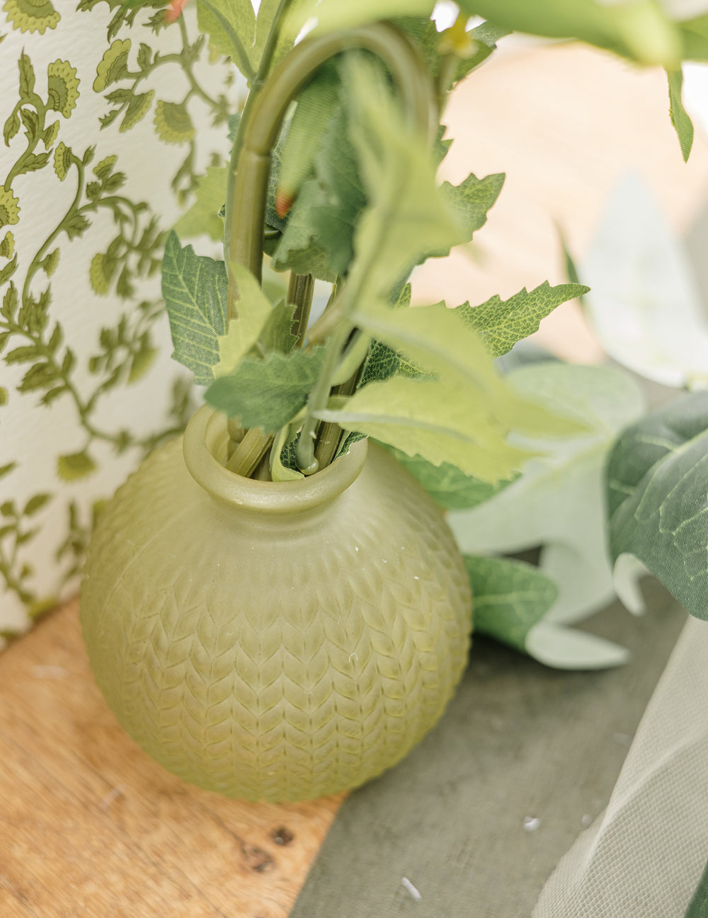 Gros plan sur le col et la texture du vase en verre ciselé style bohème