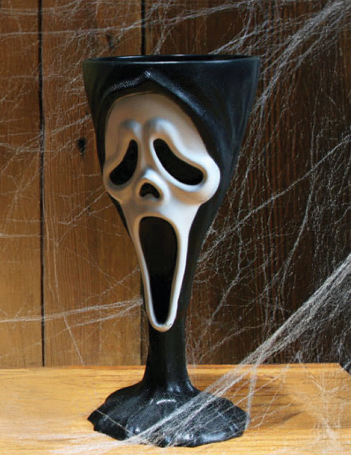 Gros plan sur le masque sculpté du verre à pied Scream™